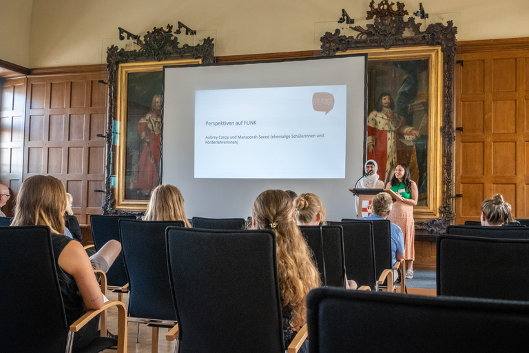 Mansoorah Saeed (vorne links) und Aubrey Czepy berichten den Gästen im Rathaussaal der Stadt Koblenz von ihren positiven Erfahrungen mit dem Projekt FUNK. Bild: Universität Koblenz-Landau