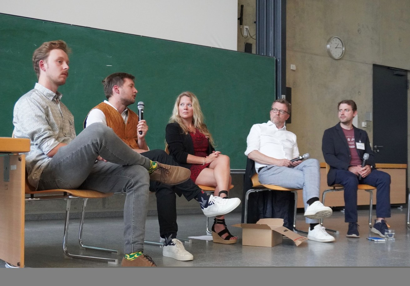 Auf dem Podium des Demokratietags diskutieren v.l.n.r.: Henrik Lenzgen, Mehr De-mokratie e.V., Jannis Graber, Referent für Strategische Steuerung Nachhaltigkeit in der Staatskanzlei Rheinland-Pfalz, Dr. Inka Engel, Referentin für Transfer und Wis-senschaftskommunikation, Universität Koblenz, Carl-Bernhard von Heusinger, Mitglied des Landtags, BÜNDNIS 90/DIE GRÜNEN, Michell Dittgen, Deutsche Gesellschaft für Demokratiepädagogik e.V., Vorsitzender des Landesverbands Rheinland-Pfalz. Bild: Universität Koblenz / Hendrik Friesenhahn