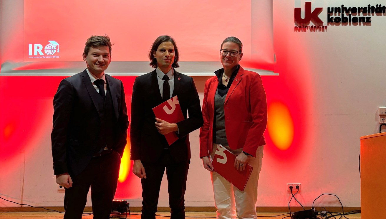 Preisträger Thomas James Schilinski (Mitte), nominiert von JProf. Dr. Andreas Weilinghoff (Lehrstuhl für Anglistik und Amerikanistik) und ausgezeichnet von Prof. Dr. Constanze Juchem-Grundmann, Vizepräsidentin für Studium und Lehre, bei der DAAD-Preisverleihung am 27. November 2024. Bild: International Relations Office